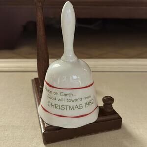 Vintage 1982 white porcelain Christmas bell with red and green details.
